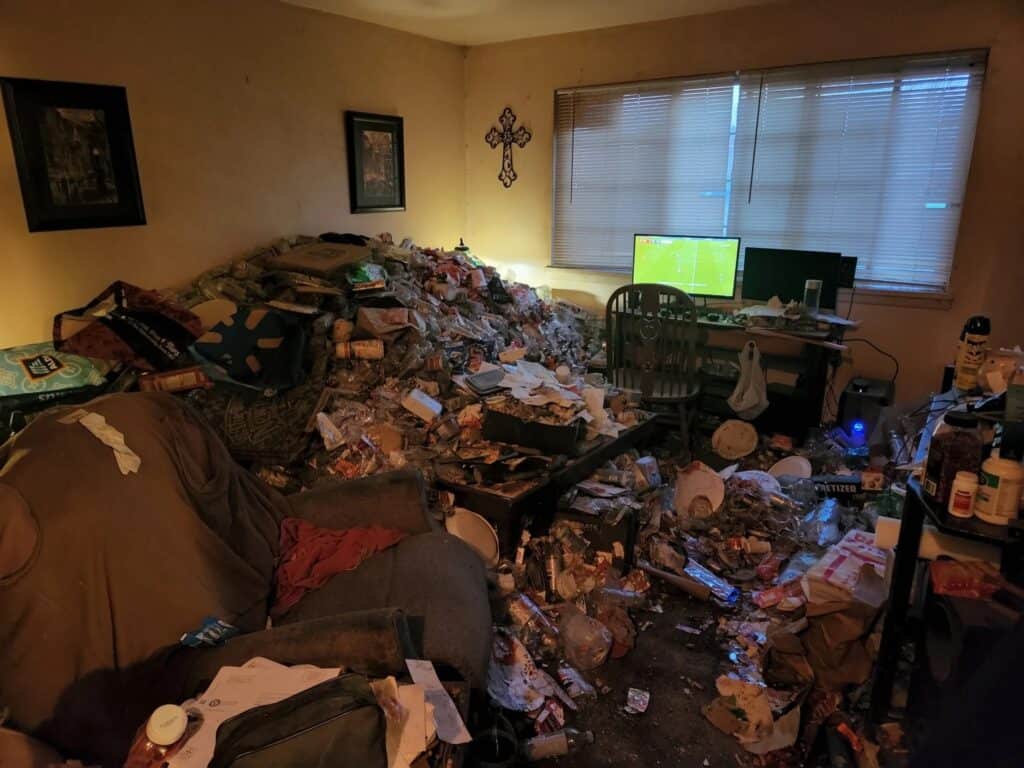 Cluttered room with trash and a visible television screen