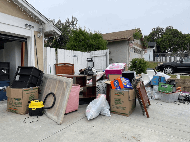 Cluttered garage sale in suburban driveway