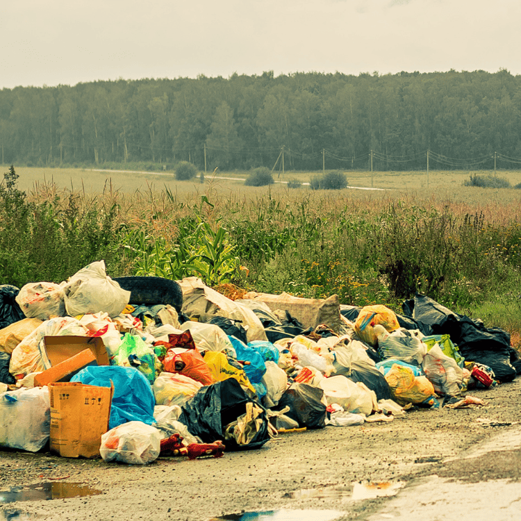 Large pile of garbage in countryside area.