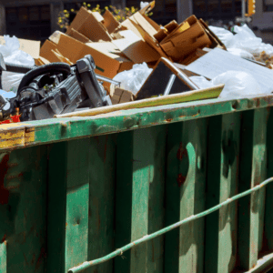 Overflowing dumpster filled with discarded items in city