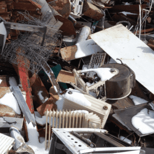 Pile of assorted metal scrap covered with snow