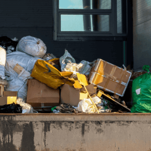 Overflowing trash bins with cardboard and plastic waste