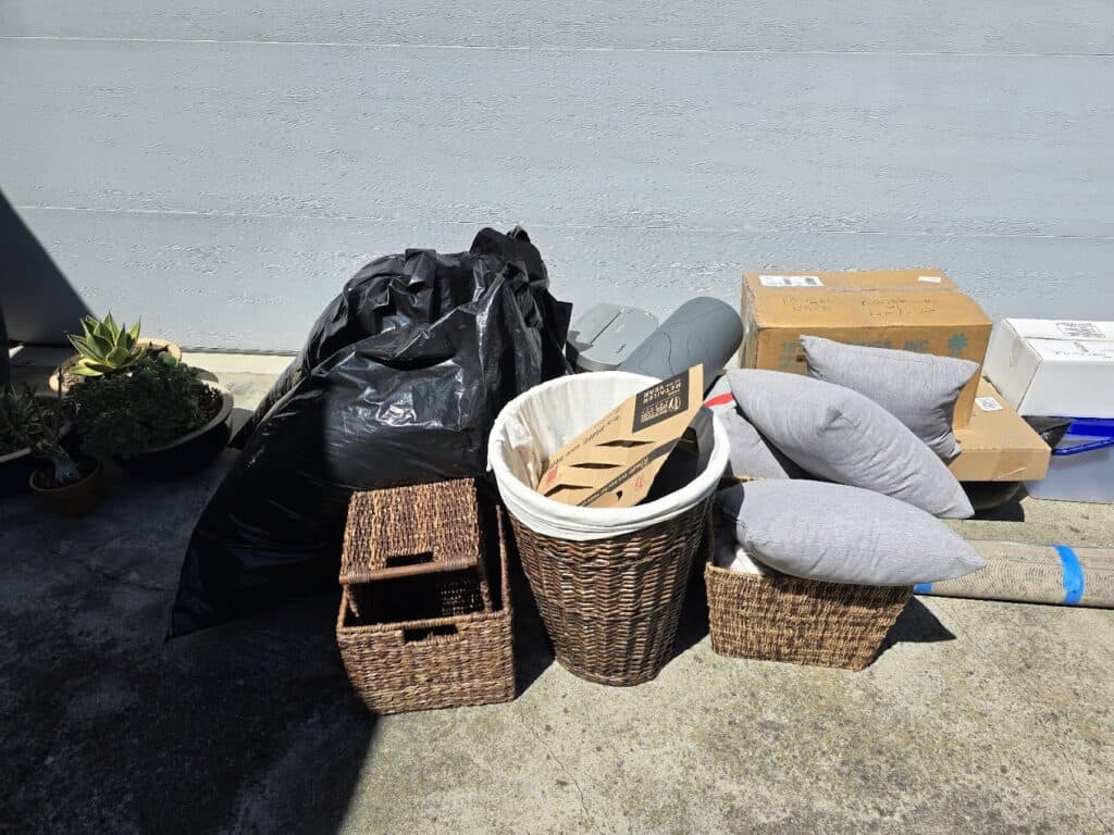 Assorted trash and recycling items on concrete sidewalk