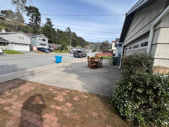 Suburban street with chairs on driveway, sunny day
