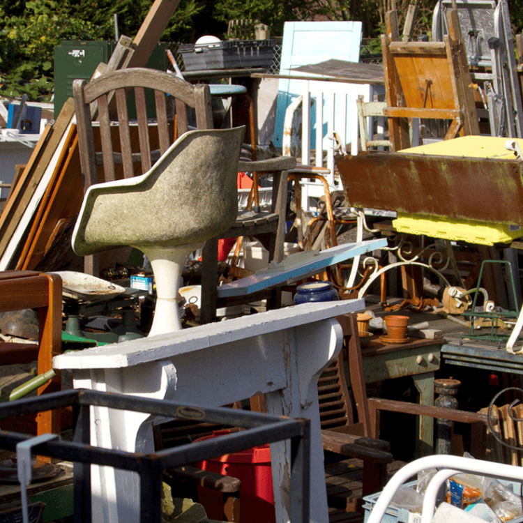 Cluttered outdoor flea market with various used items