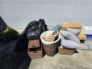 Various discarded items and boxes beside a gray wall